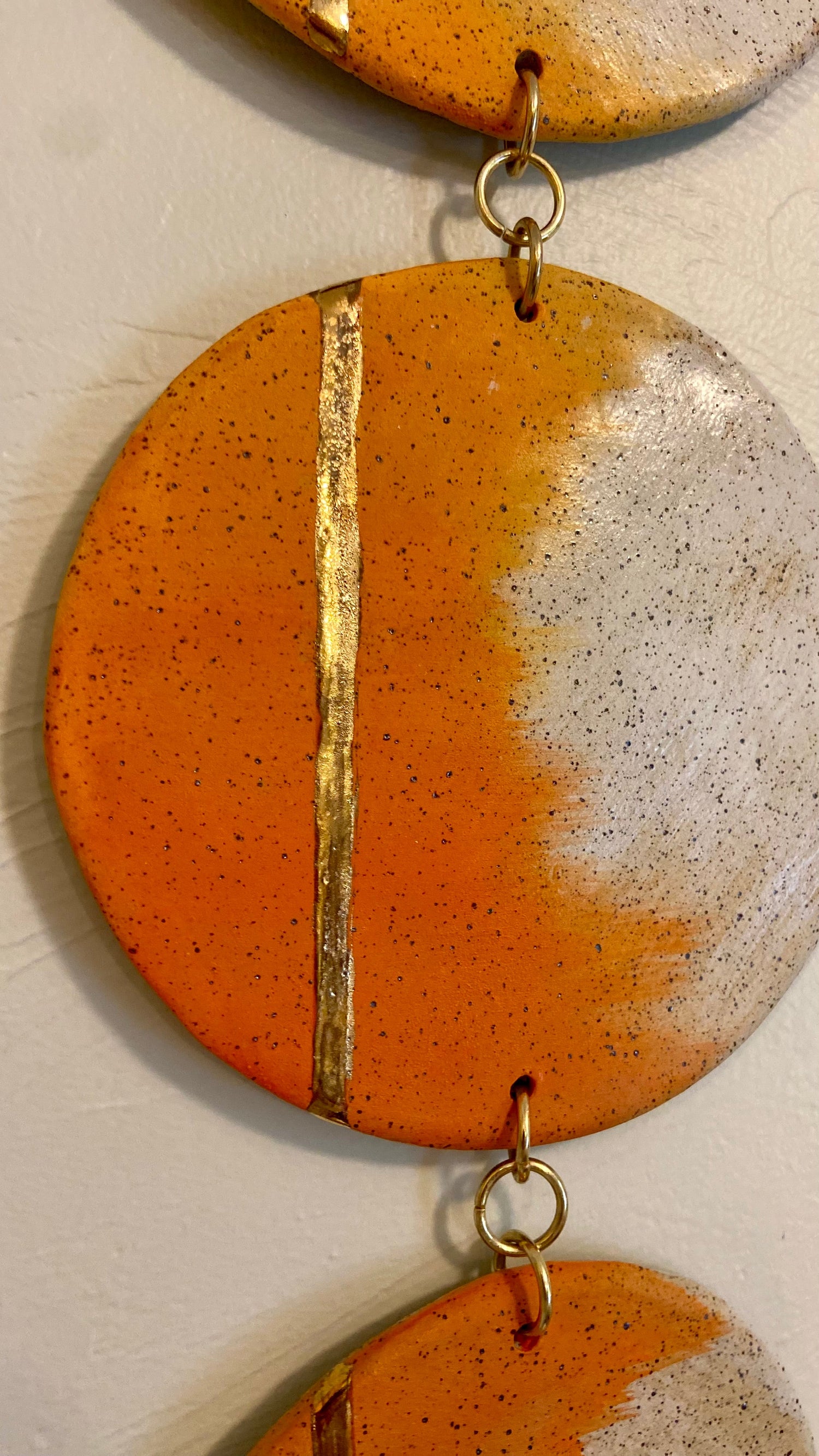 Handmade ceramic wall hanging with orange underglaze and gold luster